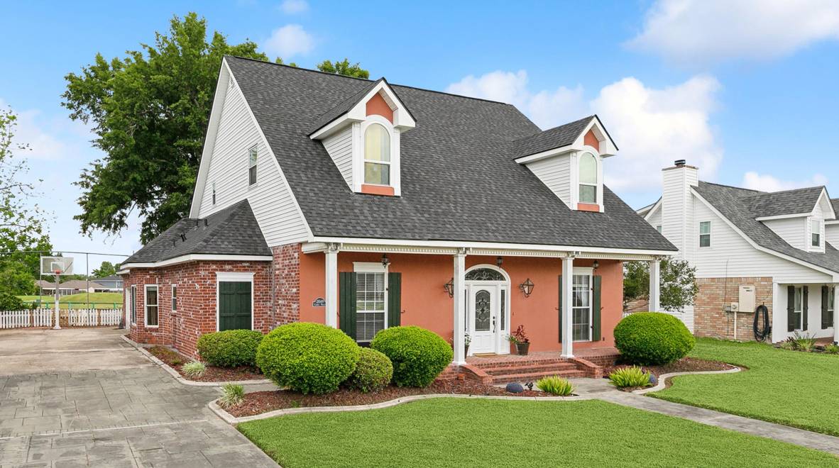 A house with a red brick roof and white trim.