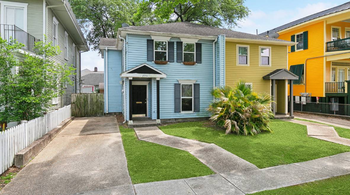 A blue house with grass in front of it.