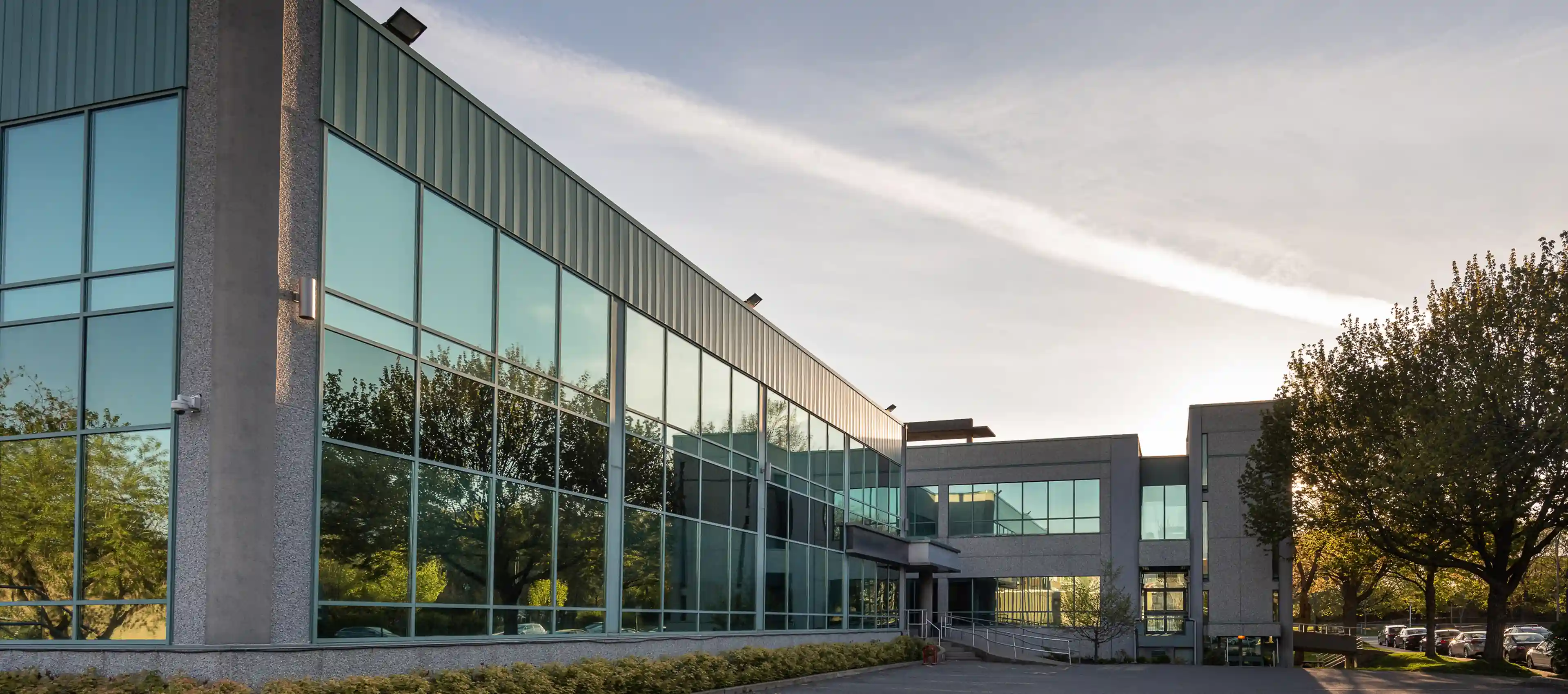 Modern glass office building with trees outside.